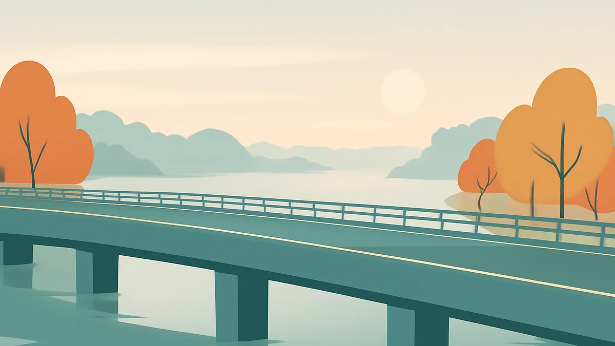 A highway bridge over a body of water with autumn trees on the banks under a pale sky with a sun