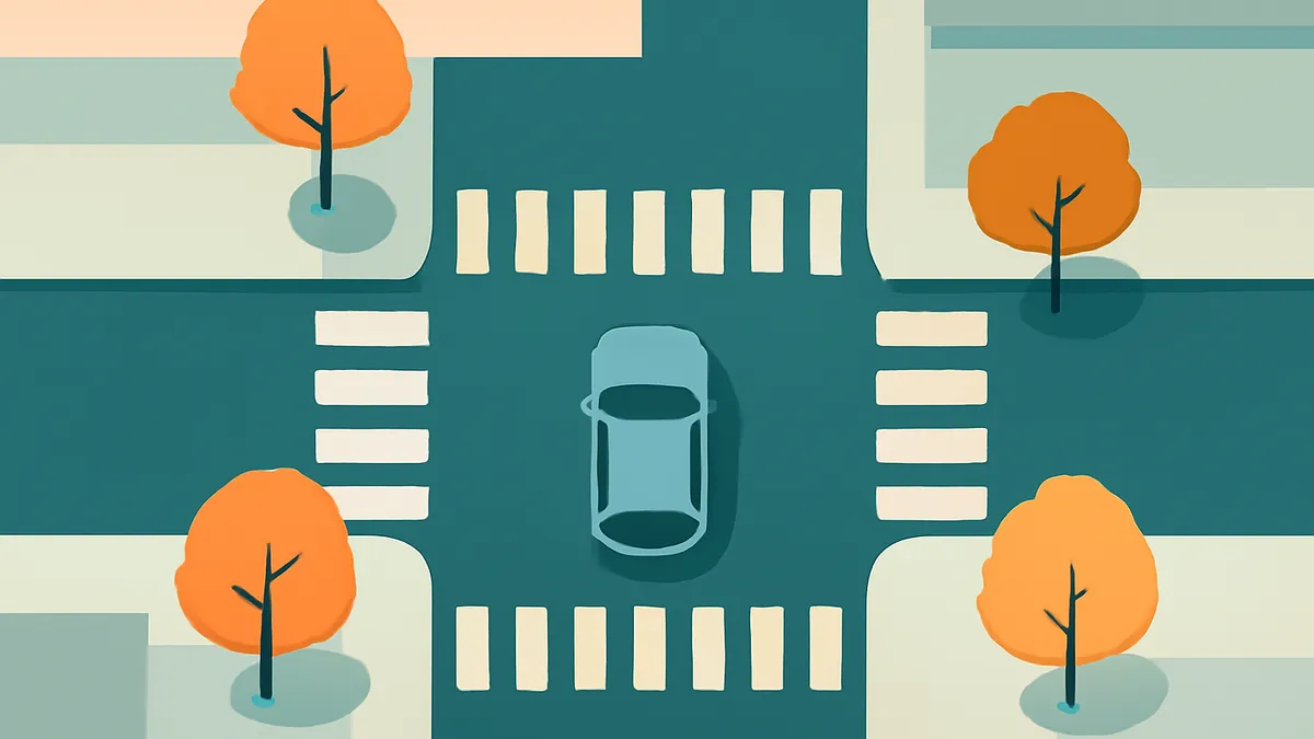 An overhead view of a light blue car at a crosswalk intersection with four orange trees on the corners