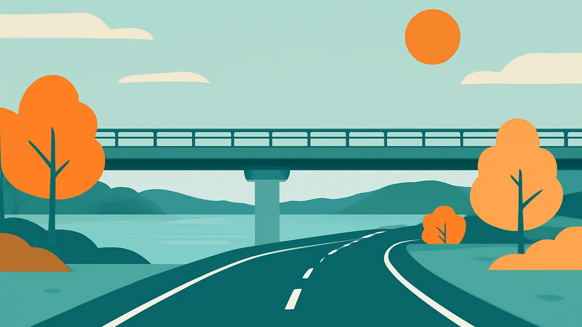 A two-lane road curves towards a bridge over a body of water, with trees and hills under a sky with a sun