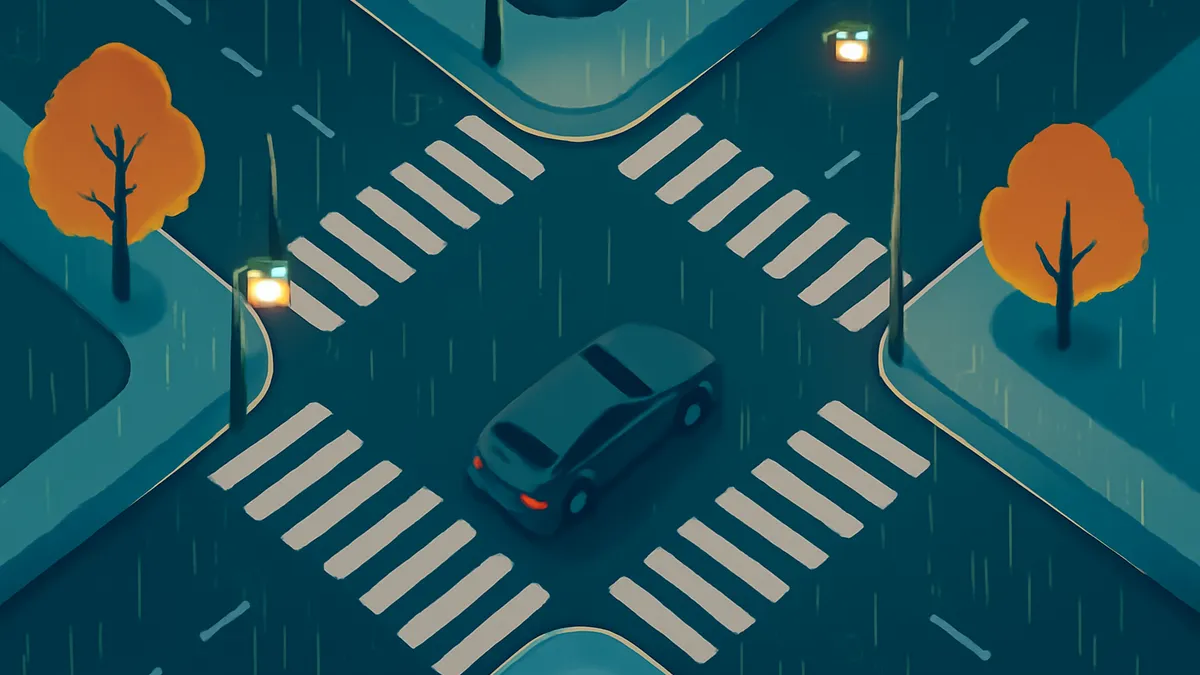 An overhead view of a car at a crosswalk on a rainy night, with two trees and streetlights