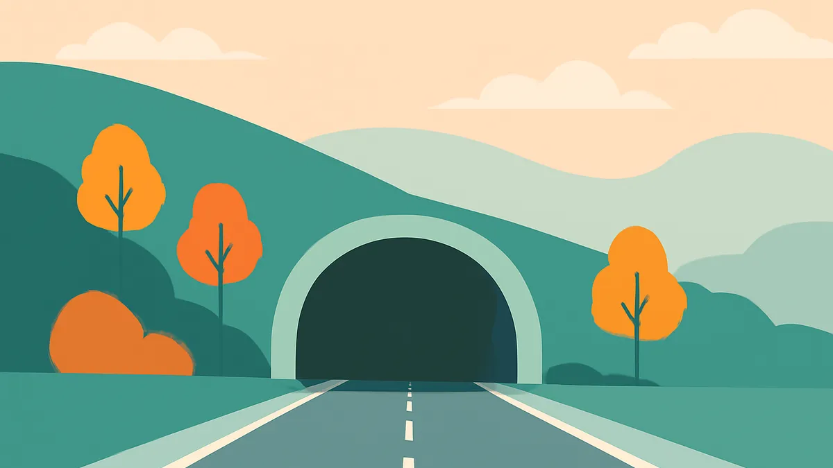 A road leading into a tunnel, flanked by hills with orange trees and bushes under a pale sky with clouds