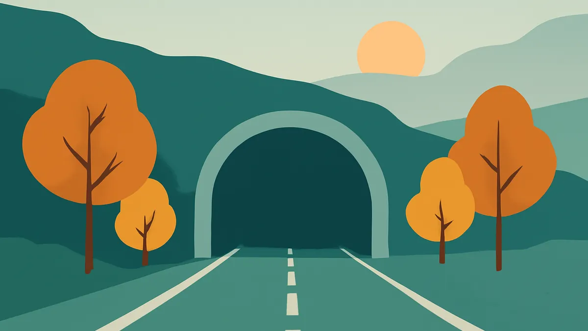 A road leading into a tunnel, flanked by trees with orange foliage, under a sky with a setting sun
