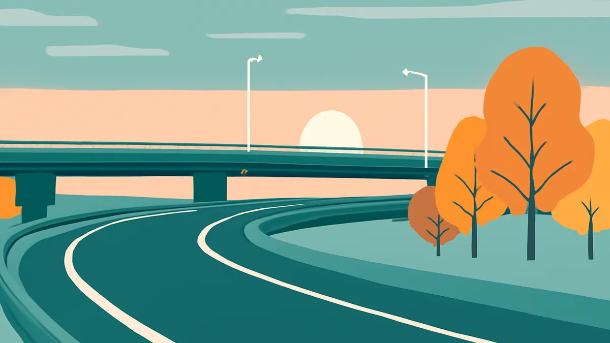 A highway with an overpass and trees in autumn colors under a sunset sky